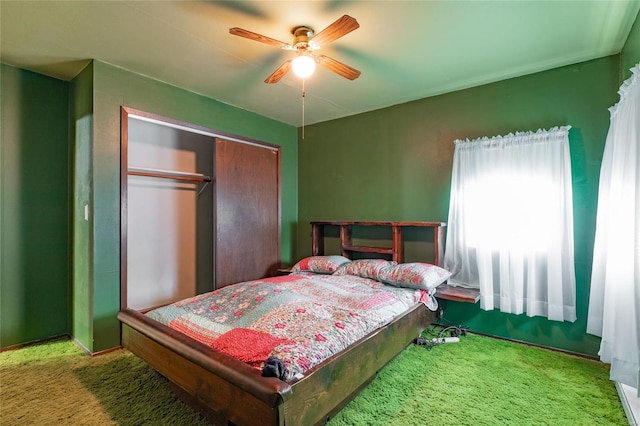 carpeted bedroom featuring ceiling fan and a closet