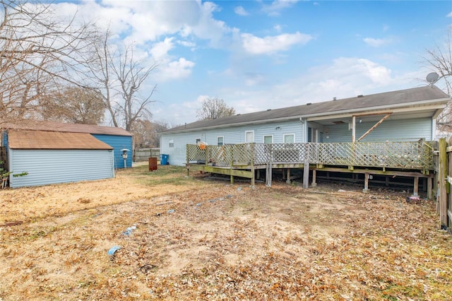 rear view of property featuring a storage shed and a wooden deck