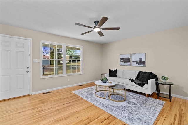 living room with ceiling fan and light hardwood / wood-style flooring