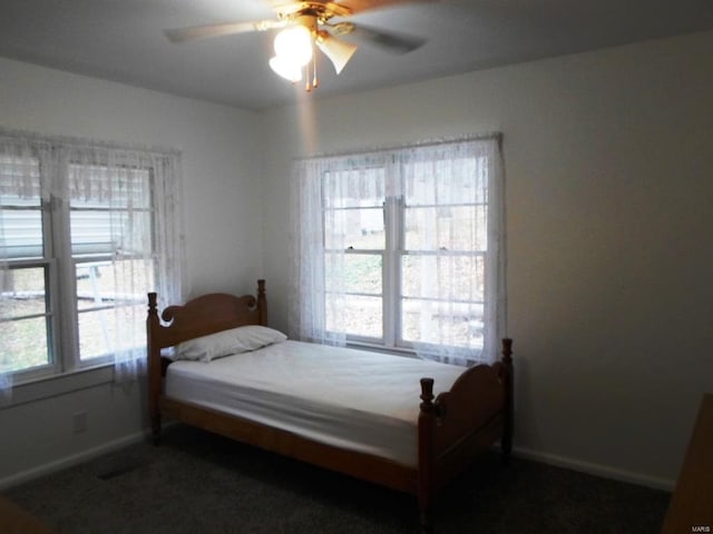 carpeted bedroom with multiple windows and ceiling fan