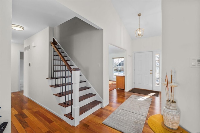 foyer entrance with hardwood / wood-style flooring and a notable chandelier