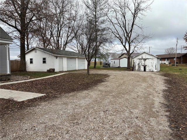 view of yard with a garage and an outbuilding