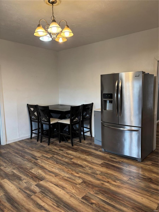 dining space featuring dark hardwood / wood-style floors and a notable chandelier