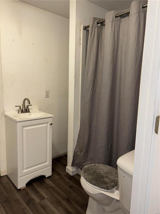 bathroom with wood-type flooring, toilet, and vanity