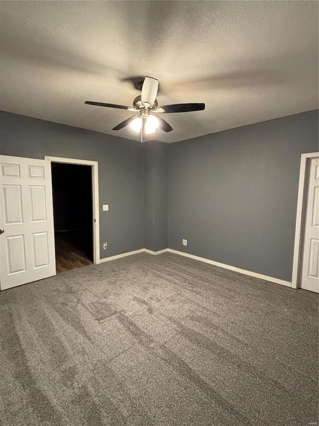 unfurnished bedroom with ceiling fan, a textured ceiling, and dark carpet