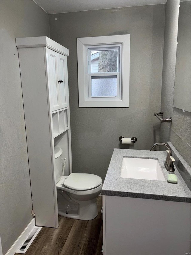 bathroom with vanity, hardwood / wood-style floors, and toilet