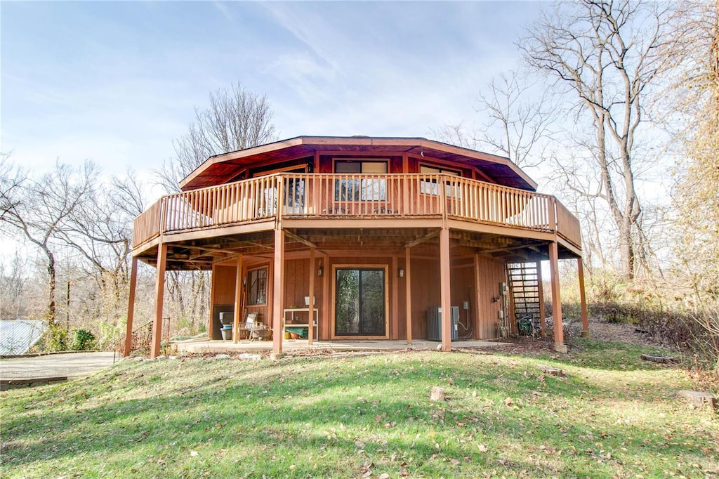 back of property featuring a wooden deck, a yard, and cooling unit