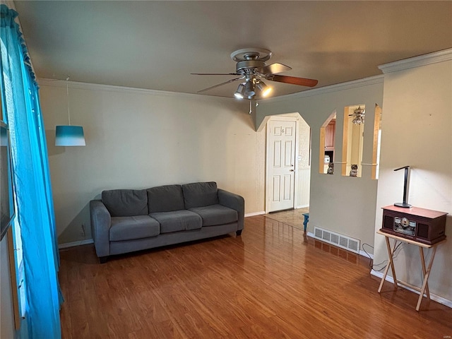 living room featuring hardwood / wood-style floors, ceiling fan, and crown molding