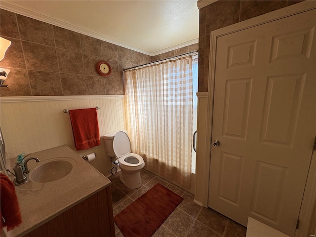 bathroom with a shower with shower curtain, tile patterned floors, ornamental molding, vanity, and toilet