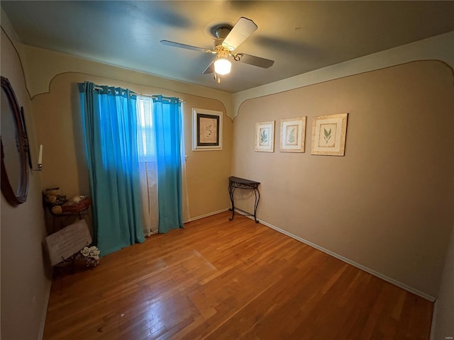 empty room with ceiling fan and wood-type flooring