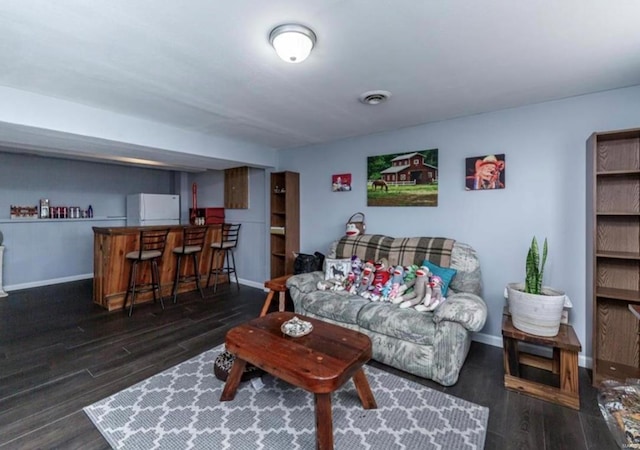 living room featuring dark wood-type flooring and indoor bar