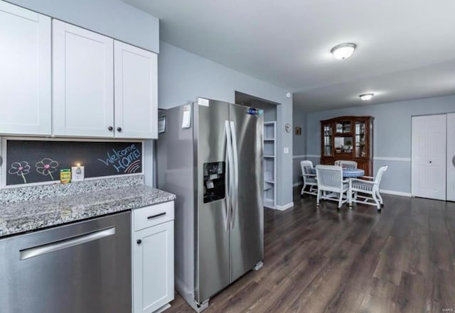 kitchen with white cabinets, light stone countertops, appliances with stainless steel finishes, and tasteful backsplash