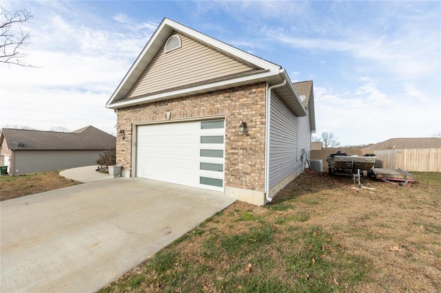 view of side of property with central air condition unit, a yard, and a garage