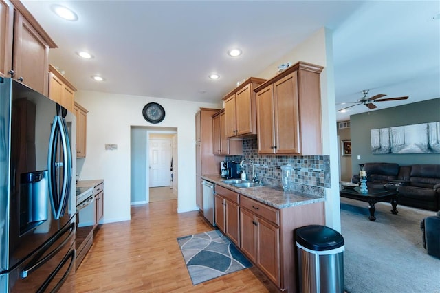 kitchen featuring sink, ceiling fan, light wood-type flooring, tasteful backsplash, and stainless steel appliances