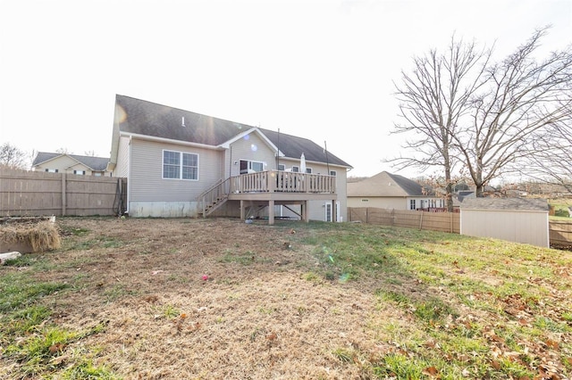 back of property with a deck, a storage shed, and a lawn