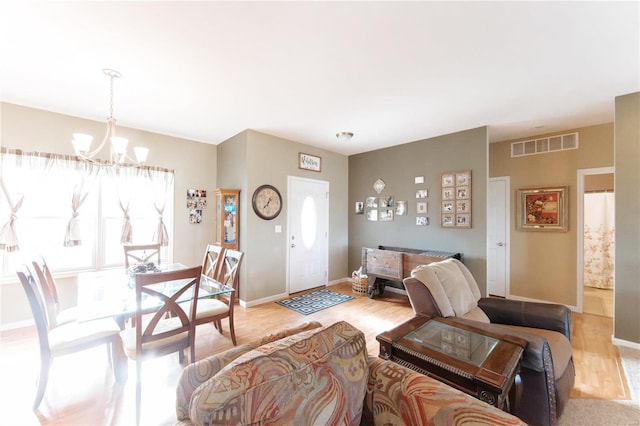 living room featuring a chandelier and light hardwood / wood-style floors