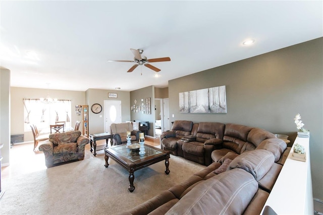 living room with ceiling fan with notable chandelier