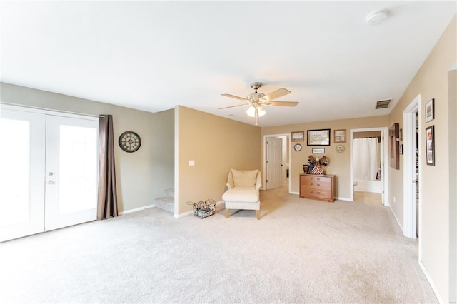 living area with light carpet and ceiling fan