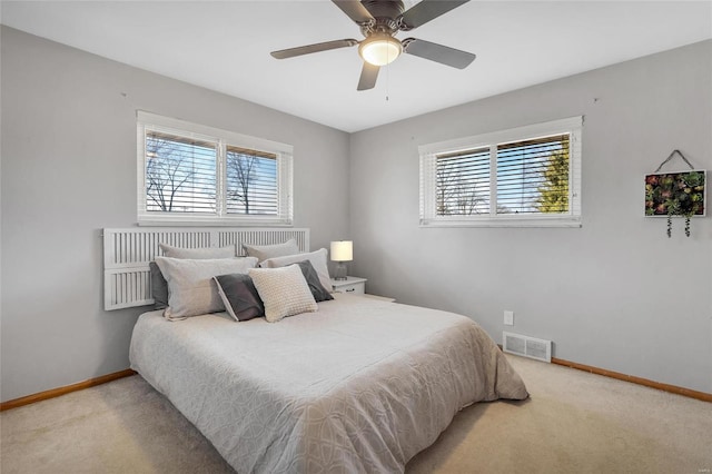 carpeted bedroom with multiple windows and ceiling fan