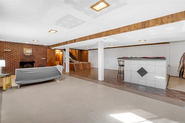 unfurnished bedroom with a fireplace, brick wall, and concrete flooring