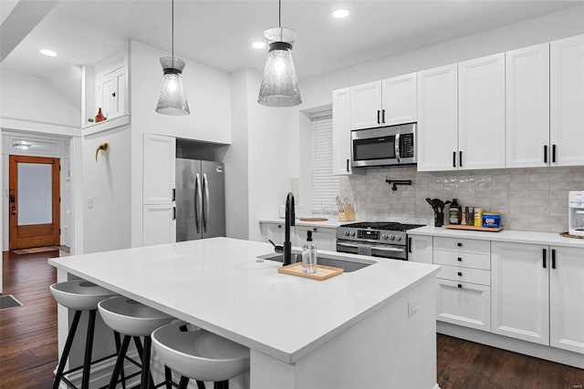 kitchen with white cabinetry, an island with sink, appliances with stainless steel finishes, and sink