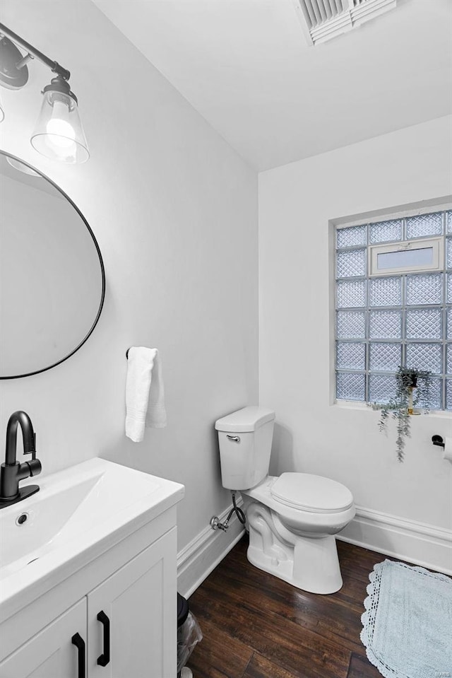 bathroom featuring wood-type flooring, toilet, and vanity