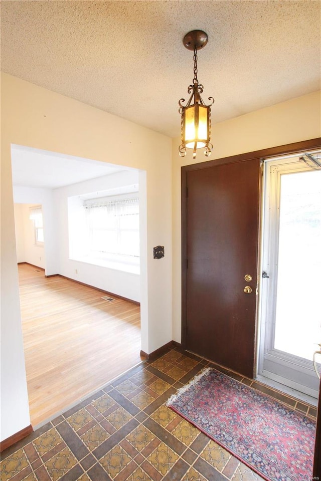 entrance foyer with a textured ceiling and dark hardwood / wood-style floors