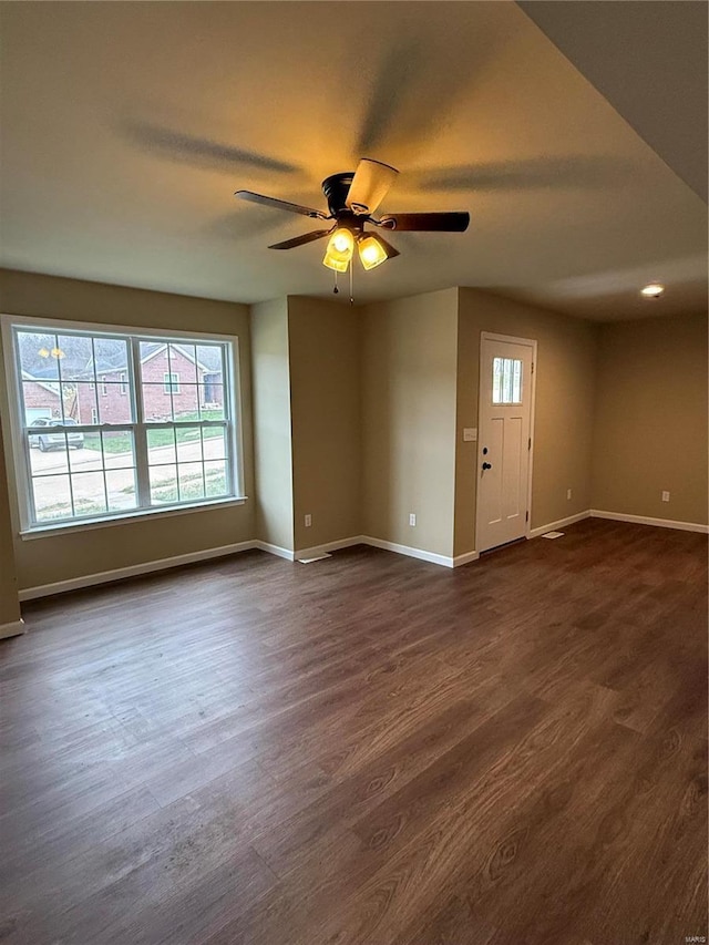 empty room with dark hardwood / wood-style flooring and ceiling fan