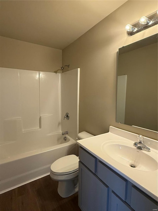 full bathroom featuring hardwood / wood-style flooring, vanity,  shower combination, and toilet