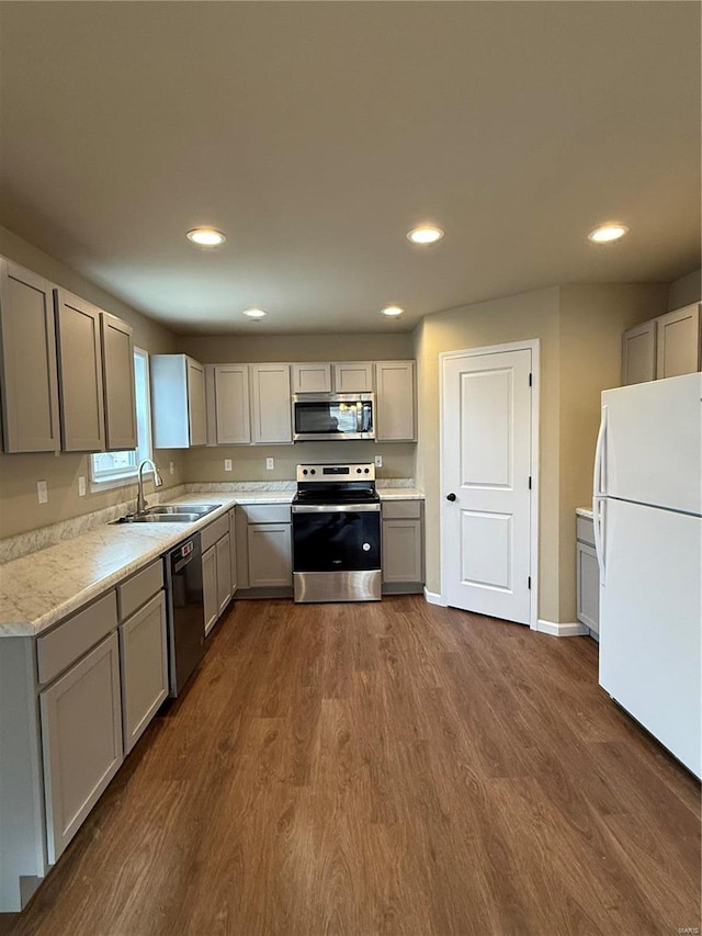 kitchen with dark hardwood / wood-style floors, gray cabinets, sink, and appliances with stainless steel finishes