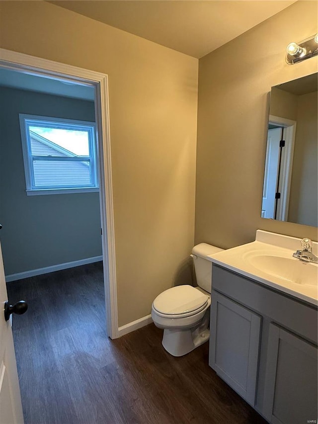 bathroom with hardwood / wood-style floors, vanity, and toilet