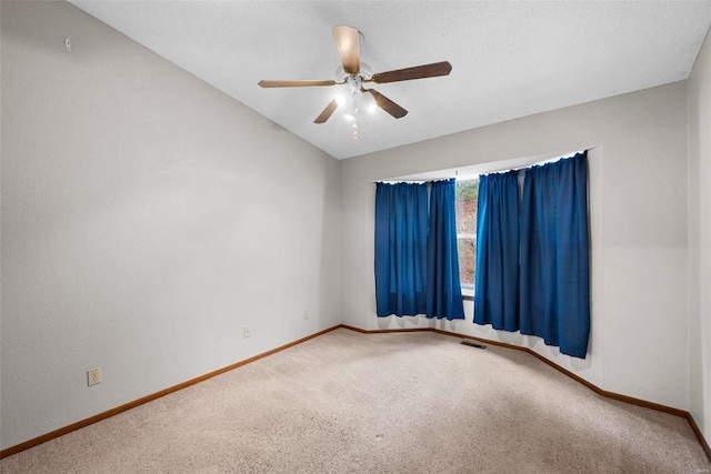 carpeted empty room featuring a textured ceiling, ceiling fan, and lofted ceiling