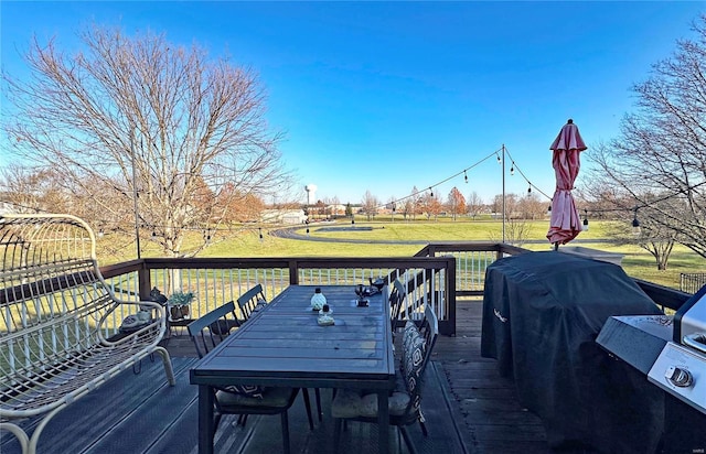 wooden terrace featuring area for grilling and a lawn