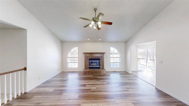 unfurnished living room with wood-type flooring, a fireplace, ceiling fan, and vaulted ceiling