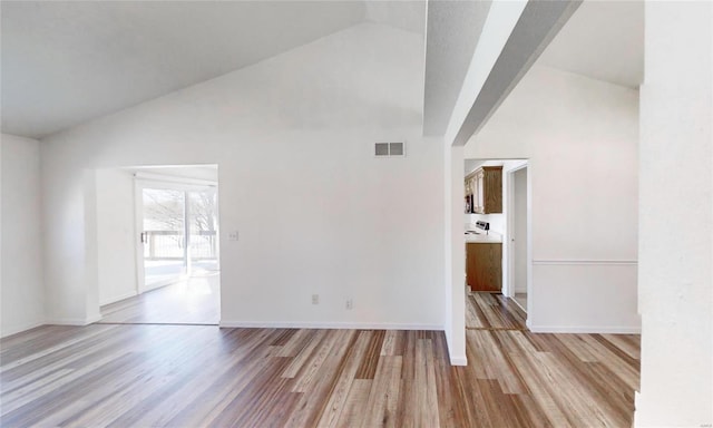 spare room featuring light hardwood / wood-style flooring and high vaulted ceiling