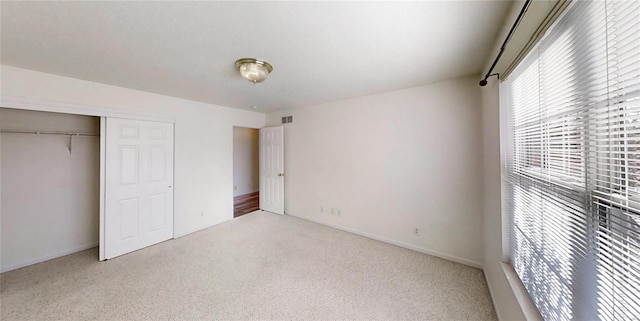 unfurnished bedroom with carpet floors and a closet