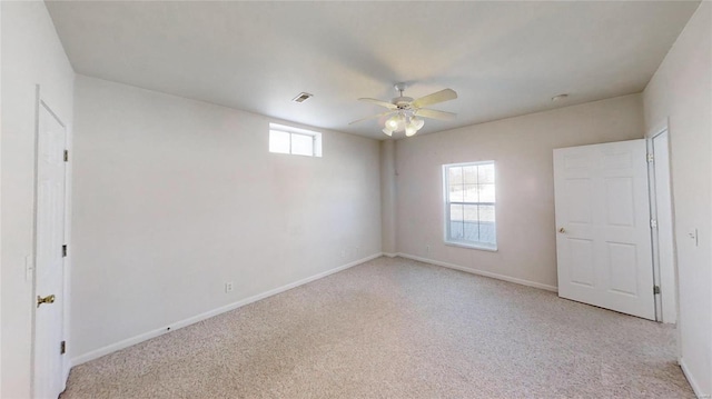 carpeted empty room with plenty of natural light and ceiling fan