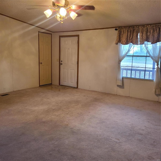 carpeted spare room featuring a textured ceiling, ceiling fan, and lofted ceiling