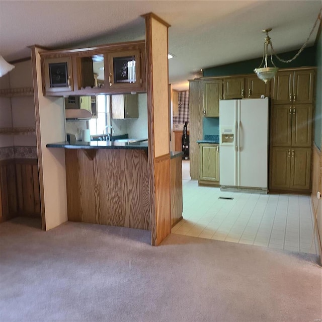 kitchen with lofted ceiling, light tile patterned flooring, white fridge with ice dispenser, and kitchen peninsula