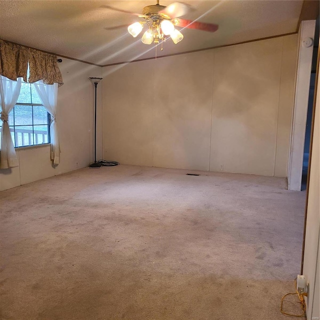 spare room featuring ceiling fan, light colored carpet, and a textured ceiling