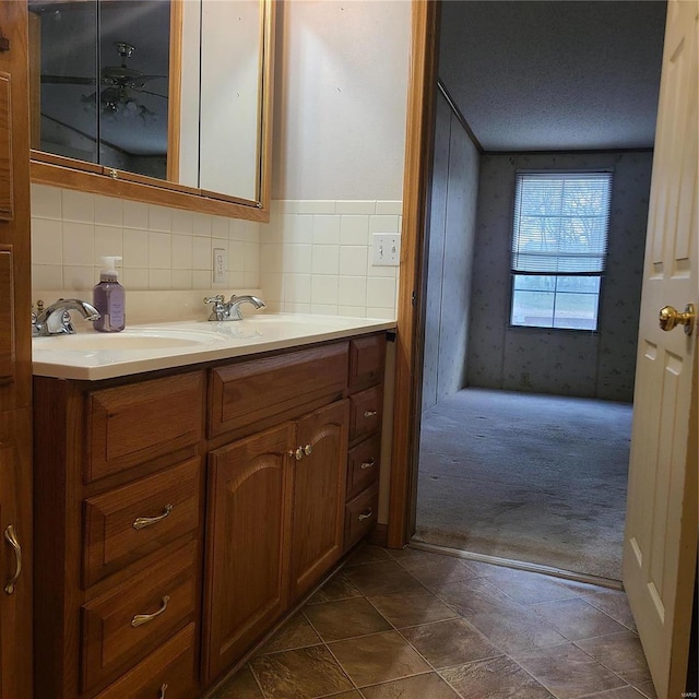 bathroom with vanity, tile patterned floors, ceiling fan, decorative backsplash, and a textured ceiling