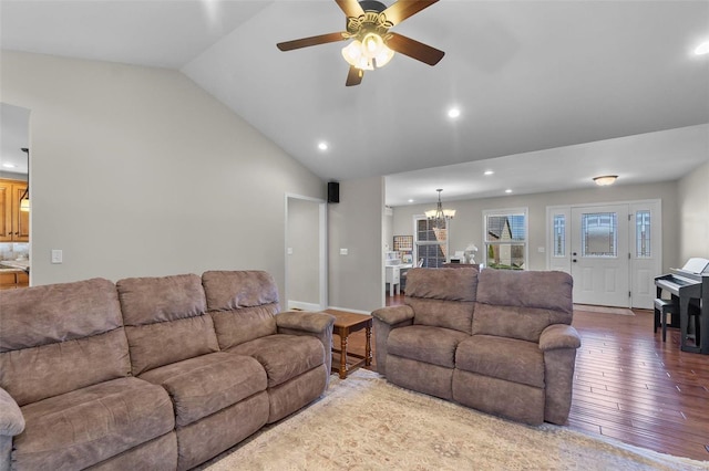 living room featuring ceiling fan with notable chandelier, lofted ceiling, and hardwood / wood-style flooring