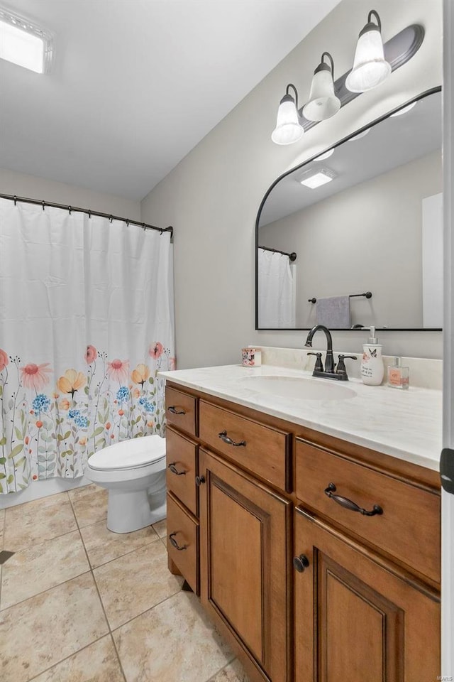 bathroom featuring tile patterned flooring, vanity, and toilet