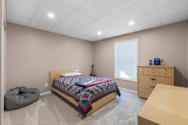 carpeted bedroom with a drop ceiling