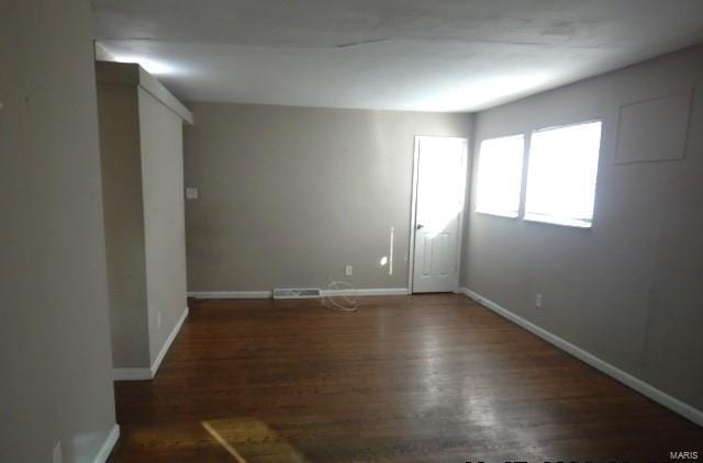 unfurnished room with dark hardwood / wood-style flooring