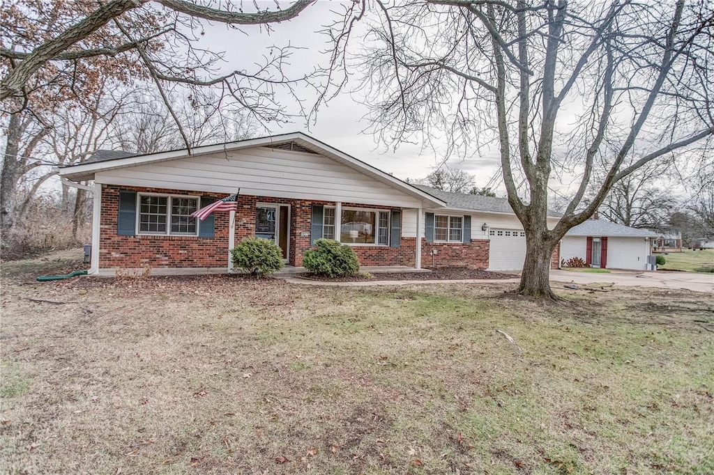 single story home featuring a garage and a front lawn