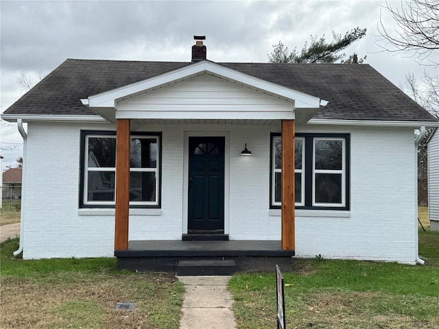 bungalow-style home featuring a front lawn and covered porch