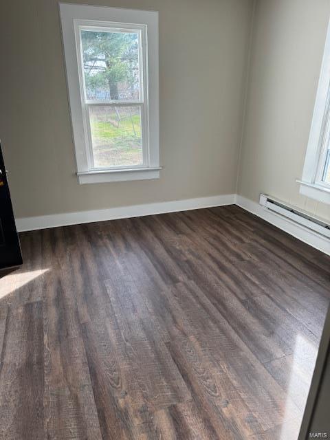 interior space featuring dark hardwood / wood-style floors, baseboard heating, and a wealth of natural light