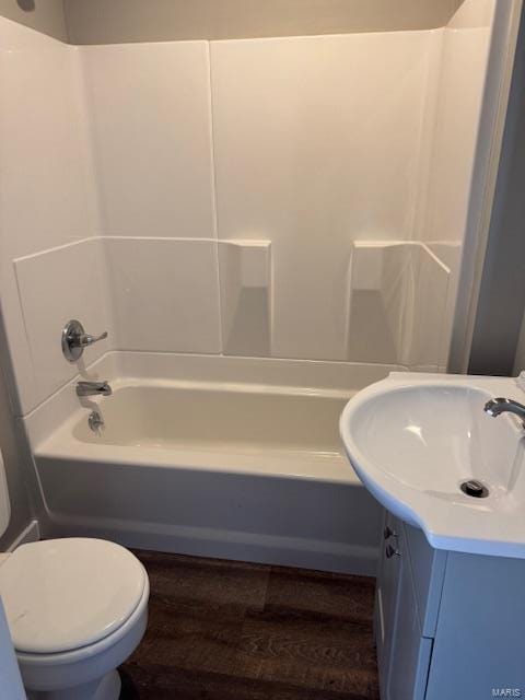 full bathroom featuring hardwood / wood-style floors, vanity, toilet, and shower / washtub combination