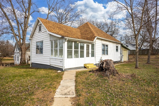 back of property featuring a lawn and a sunroom